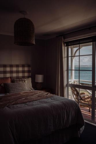 a bedroom with a bed and a view of the ocean at Little Talisker in Stanley