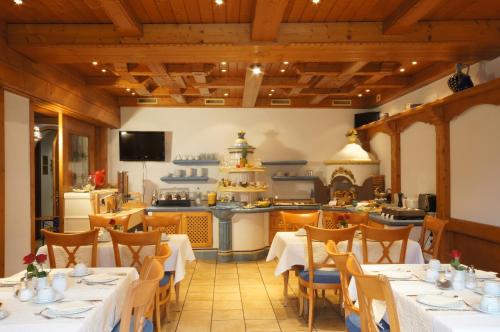 un restaurante con mesas y sillas y una cocina en Zum Waldnaabtal, en Windischeschenbach