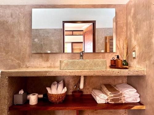 a bathroom with a sink and a mirror and towels at Casa Chiquilluma in Piedra Blanca