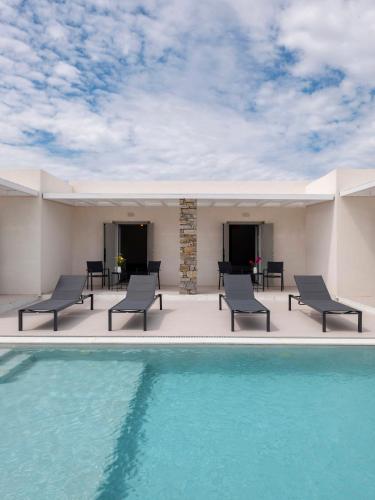 a patio with chairs and a swimming pool at Amouage Studios in Kampos Paros