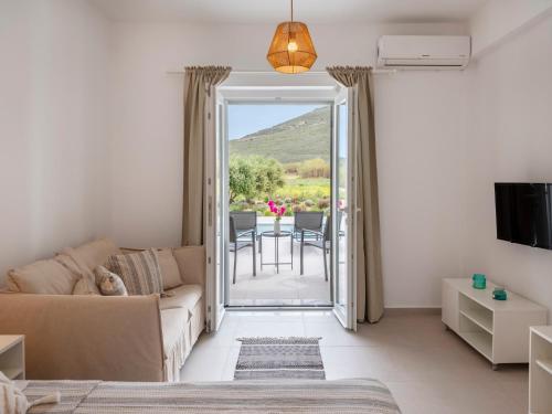 a living room with a couch and a door leading to a patio at Amouage Studios in Kampos Paros