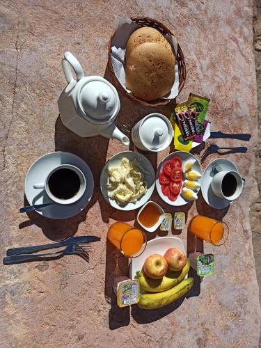uma mesa com um monte de alimentos para o pequeno almoço e café em Jurassic Hostal em Torotoro