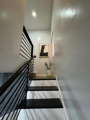 a staircase in a house with white walls at Pastora House Luxe Staycation Bauan Batangas in Bauan