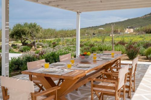 a wooden table and chairs on a patio with a view at Amouage Studios in Kampos Paros
