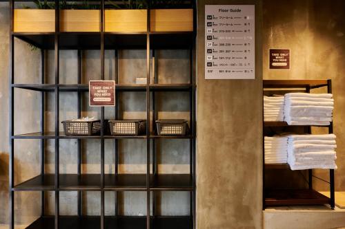une étagère avec des serviettes et des paniers dans un magasin dans l'établissement ホテルコンテニュー二条城北, à Shimo-dachiyuuridōri
