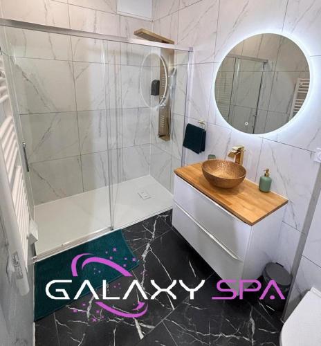 une salle de bain avec un lavabo et un miroir dans l'établissement GALAXY SPA - Suite Jupiter Jacuzzi Privatif, à Champigneulles