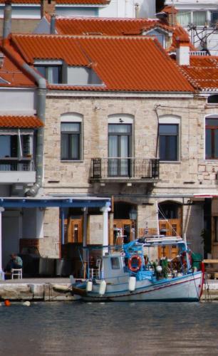 a boat is docked in front of a building at The Stonehouse at the Harbor in Pythagoreio