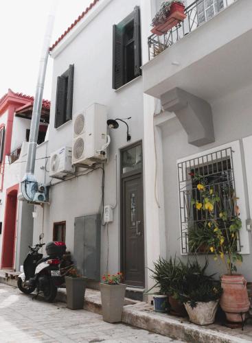 a scooter parked in front of a white building at The Stonehouse at the Harbor in Pythagoreio