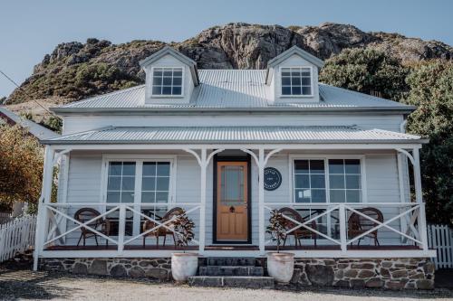 a white house with a mountain in the background at Little Talisker in Stanley