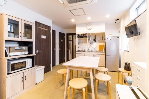 een keuken met een tafel en stoelen in een kamer bij ホステル祇園SORA in Kyoto