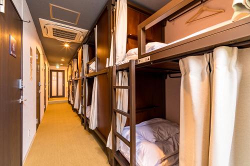 eine Reihe von Etagenbetten in einem Schlafsaal in der Unterkunft ホステル祇園SORA in Kyoto