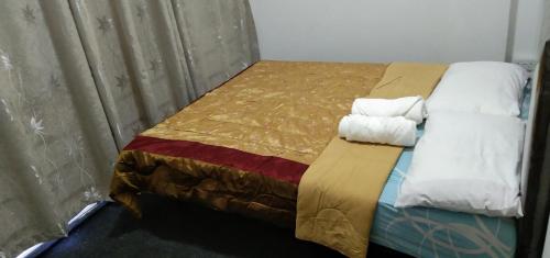 1 dormitorio con 1 cama con toallas en Melrose homestay and transport, en Bandar Seri Begawan