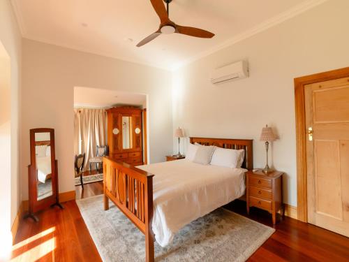a bedroom with a bed and a ceiling fan at Maddies of Bolwarra in Maitland