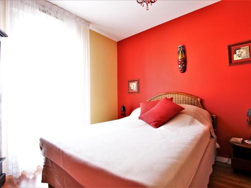 - une chambre rouge avec un lit avec un mur rouge dans l'établissement Appartement Tout Confort entre Plage et Commerces à Saint-Brevin-les-Pins - FR-1-364-55, à Saint-Brévin-les-Pins