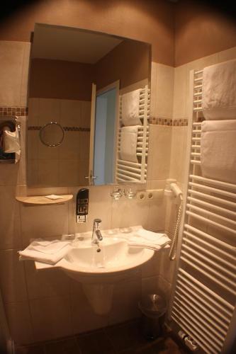 a bathroom with a sink and a mirror and towels at Hotel Knipper in Lastrup