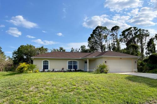 a house with a garage on a lawn at Cozy 3 Bedroom Vacation Home in North Port