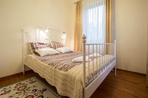 a bedroom with a white bed and a window at Apartamenty Willa Radowid Zakopane in Zakopane