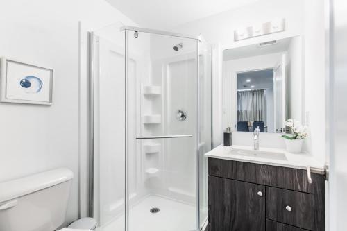 La salle de bains blanche est pourvue d'une douche et d'un lavabo. dans l'établissement New Luxury Suite 6Mins To Falls, Free Parking, à Niagara Falls
