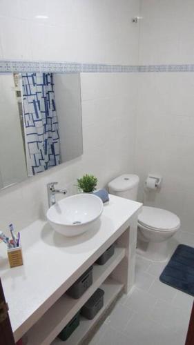 a white bathroom with a sink and a toilet at Casa Amin Tolu in San Silvestre