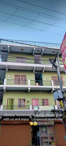 a building with a sign on the side of it at Limewood homestay in Almora