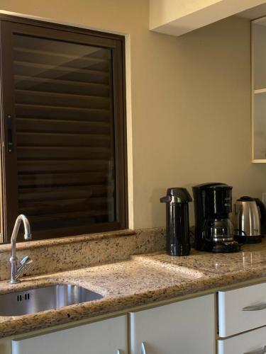 un bancone della cucina con lavandino e macchinetta del caffè di Espaço no Centro a Lauro Müller