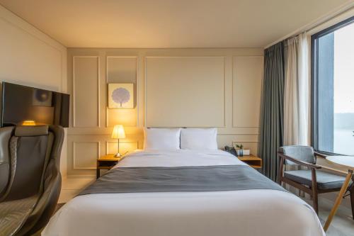 a hotel room with a large bed and a window at JK Blossom Hotel in Seoul