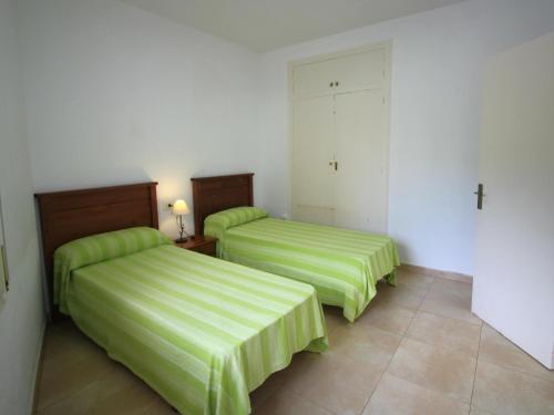 - 2 lits dans une chambre d'hôtel avec des draps verts dans l'établissement Apartamento Llançà, 3 dormitorios, 6 personas - ES-228-37, à Llançà
