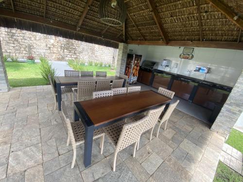 a wooden table and chairs on a patio at Apt Alto da Serra Villas - Bananeiras in Bananeiras