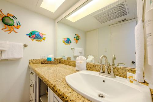 a bathroom with a sink and a mirror at Seagulls Serenade Cozy 1BR Hideaway near Beach 206 in South Padre Island