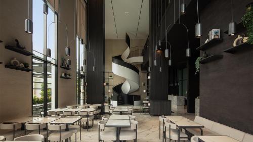 a restaurant with tables and chairs in a hallway at REZ Hotel in Semarang