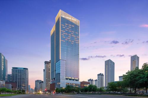 a tall skyscraper in a large city at dusk at Crowne Plaza Jinan Runhua in Jinan