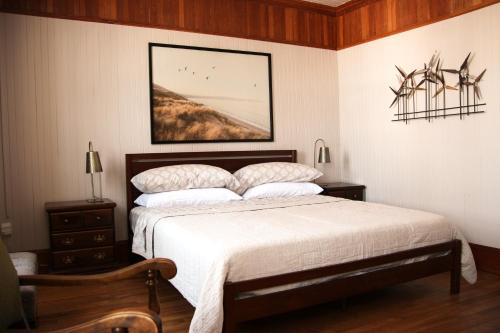 a bedroom with a bed and a picture on the wall at Auberge Comme au premier jour in Saint-Pacôme