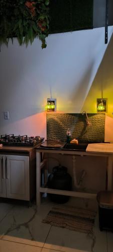 a kitchen with a sink and a counter with lights at Apartamento Confort Loft 01 in Ponta Porã