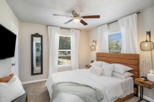a bedroom with a bed with a ceiling fan and windows at The Southern Sapphire - A Cozy Lake View Getaway in Granbury