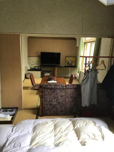 a bedroom with a bed and a table and a tv at Sawa no Yado Kinsenkaku - Vacation STAY 45272v in Date