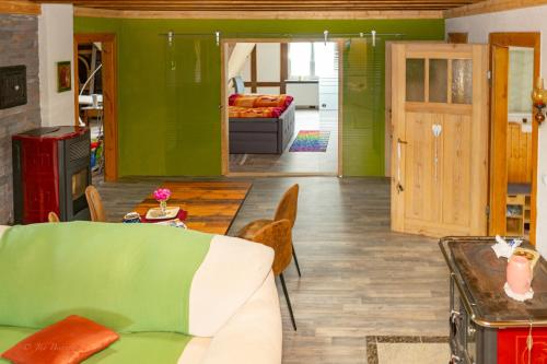 a living room with green walls and a couch at Wohlfühl-Villa in Themar in Themar