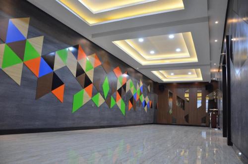 een hal met een muurschildering van kleurrijke driehoeken aan de muur bij BLESS HOTELS in Sintang