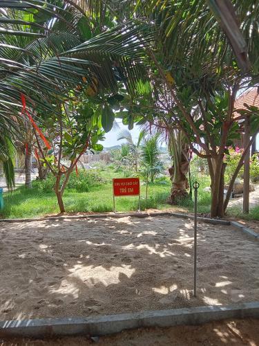 a sign in the middle of a park with trees at Biển Ngọc Homstay in Ấp Sung Xuân