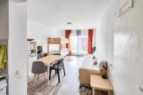 Cette chambre comprend un bureau, un lit et une table. dans l'établissement Résidence Les Chalets de Puy Saint Vincent - maeva Home - Studio 4 personnes - Sélection MAE-9031, à Narreyroux