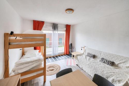 un salon avec un lit superposé et un canapé dans l'établissement Résidence Les Chalets de Puy Saint Vincent - maeva Home - Studio 4 personnes - Sélection MAE-9031, à Narreyroux