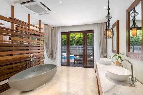un bagno con due lavandini e una grande vasca di SAii Koh Samui Choengmon a Choeng Mon Beach