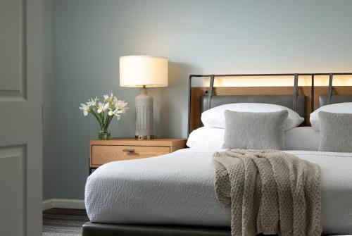 a bedroom with two beds and a table with a lamp at Meadowbrook Inn in Blowing Rock
