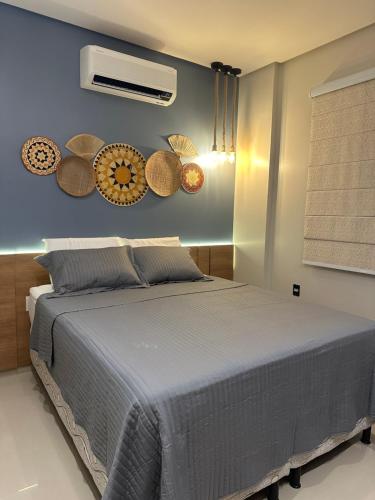 a bedroom with a bed with baskets on the wall at Flat Alter do chão - Ilha bela Residence in Alter do Chao