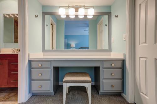 a bathroom with a vanity with a mirror and a stool at Evian 156 in Hilton Head Island