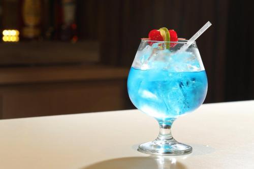 a blue drink in a glass sitting on a table at Holiday Inn Tijuana Zona Rio by IHG in Tijuana