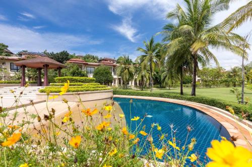 einen Pool in einem Garten mit Palmen in der Unterkunft Laguna Park Townhomes & Villas in Strand Bang Tao