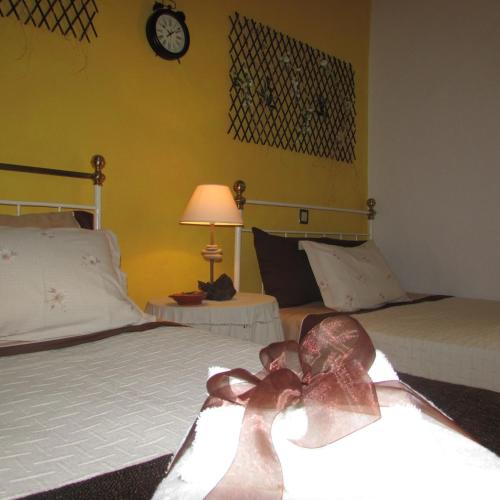 a bedroom with two beds and a clock on the wall at Cerca da Ponte in Almodôvar