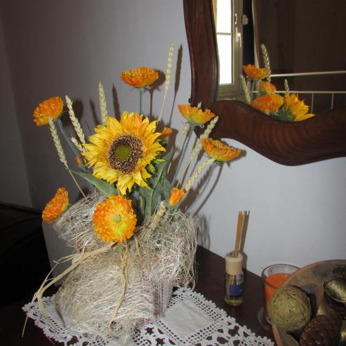 a vase filled with orange flowers on a table at Cerca da Ponte in Almodôvar