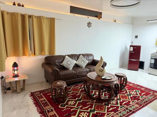 a living room with a brown couch and a red rug at La Mar Box 7 frente al Mar - Parejas in Pichilemu