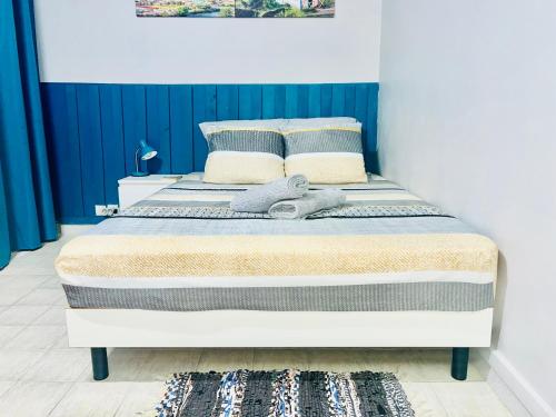 Ce lit se trouve dans une chambre dotée d'un mur bleu et blanc. dans l'établissement Belle Vue ASCENSEUR WIFI CLIM, à Fort-de-France